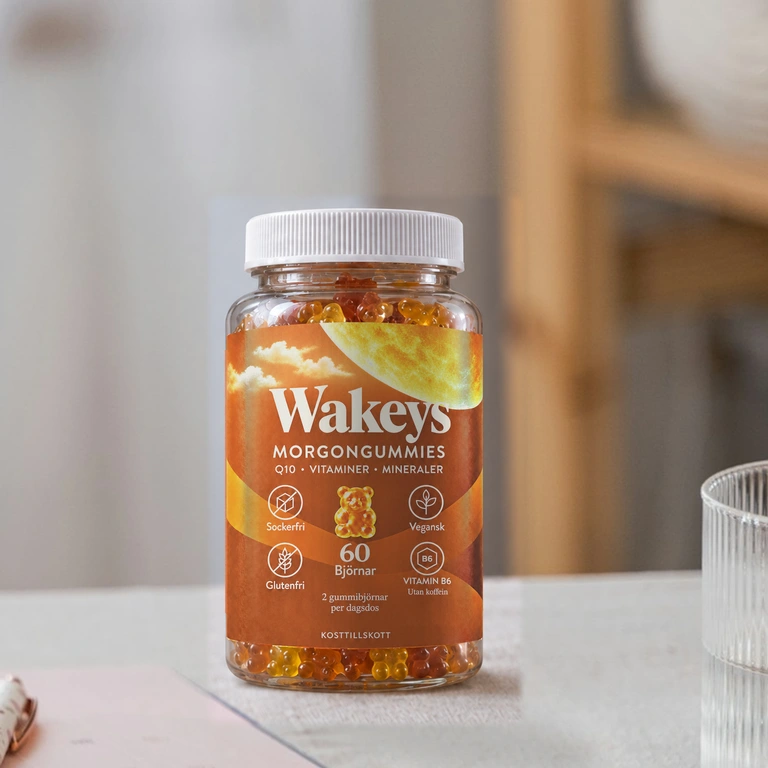 Wakeys-burken vid en anteckningsbok och ett glas vatten i dagsljus